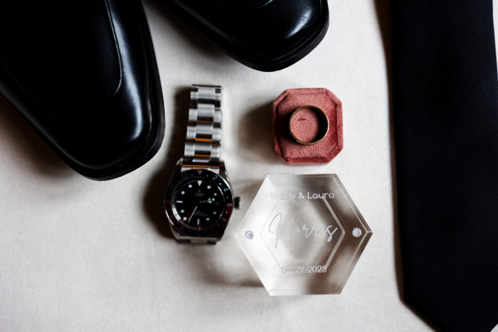 Groom's details including shoes, watch, wedding band, tie, and ring boxes.