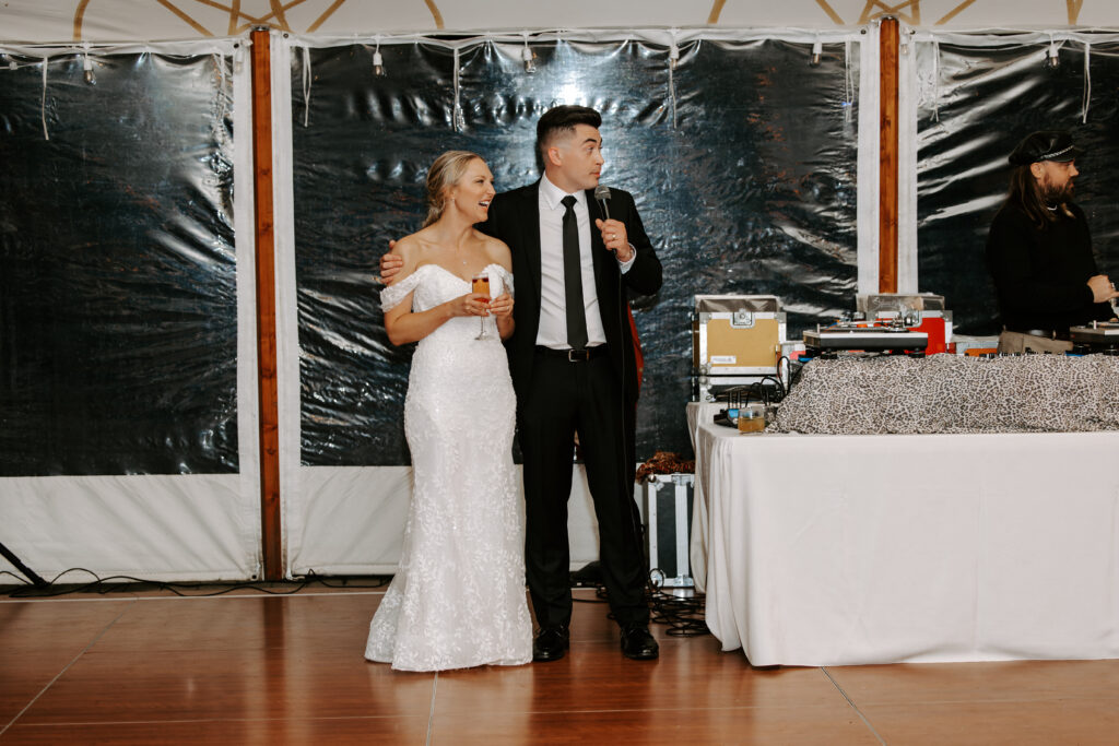 Bride and groom give a welcome speech to guests at their rainy wedding at The Willowdale Estate in Topsfield, Massachusetts.