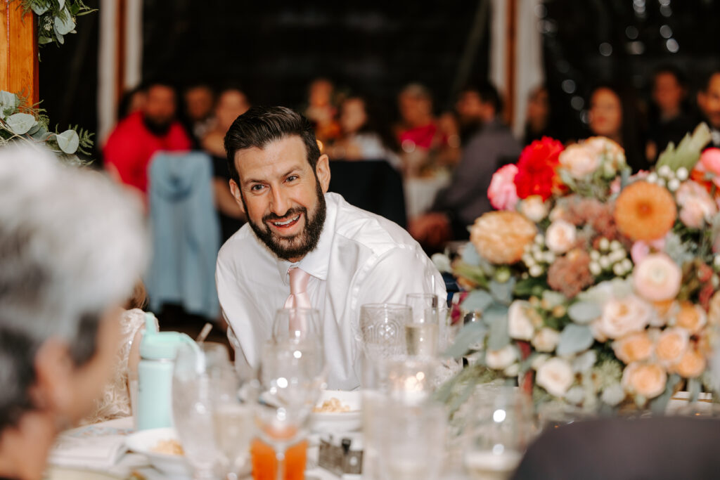 Guests laugh during toasts at rainy fall wedding at The Willowdale Estate in Topsfield, Massachusetts
