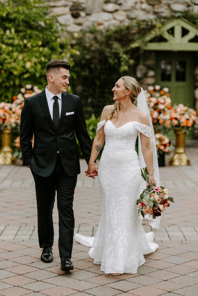 Bride and groom hold hands and walk for portraits at their wedding at The Willowdale Estate.