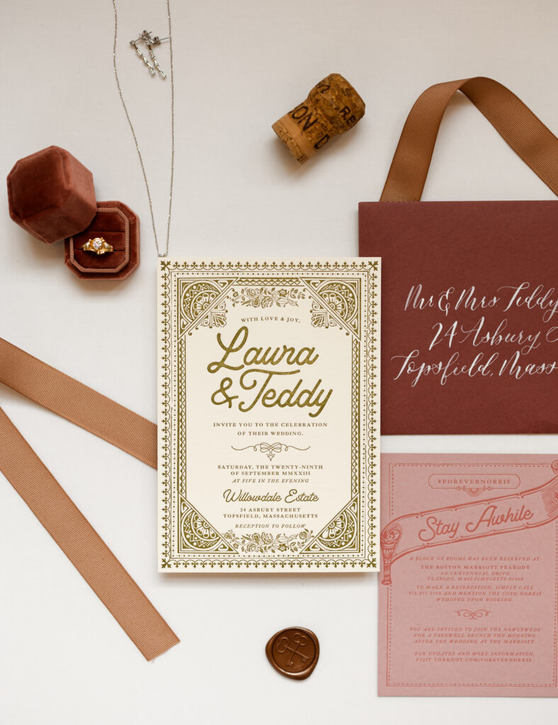 Wedding details and invitation suite including engagement ring, necklace, earrings, and ring box