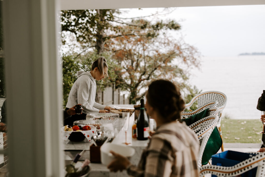 Bridesmaids arrange food and drinks while getting ready for bride's wedding.