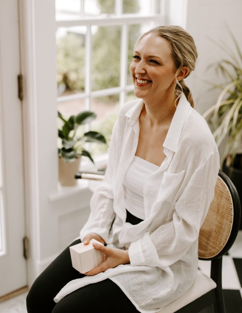 Bride smiles as she gets her hair and makeup done for her fall wedding at the Willowdale Estate in Topsfield, MA.