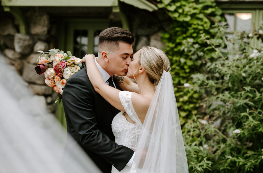 Bride and groom kiss with a beautiful veil swoop before their fall wedding at The Willowdale Estate.