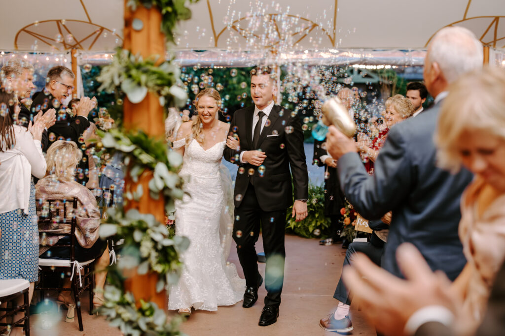 Bride and groom walk back down the aisle as husband and wife during their rainy wedding ceremony at The Willowdale Estate.