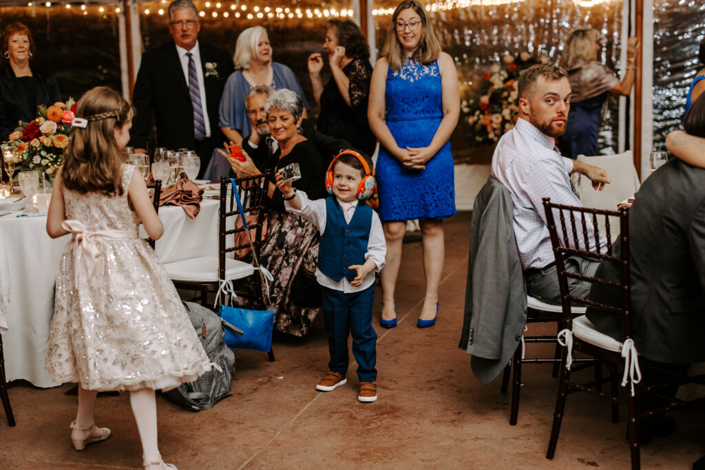 Little boy takes a photo of his older sister at fall wedding reception at The Willowdale Estate.