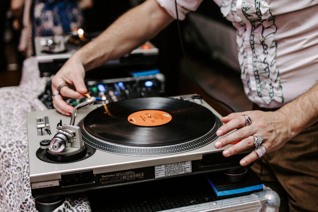 The Glitter Boys putting a record on the record player for fall wedding reception at The Willowdale Estate.