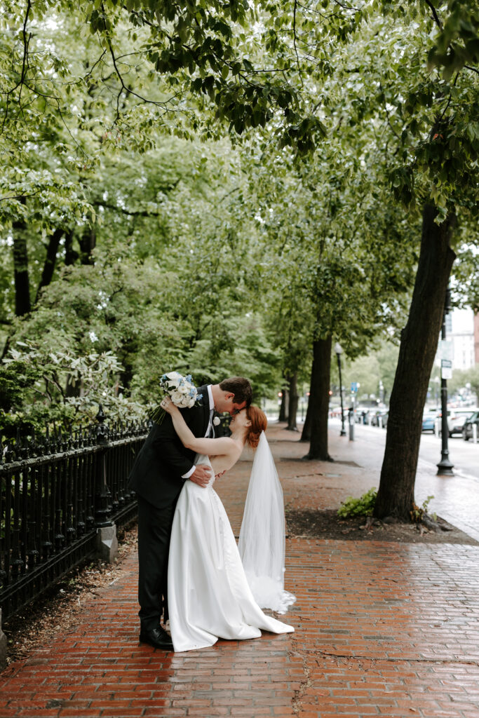 Bride and groom touch foreheads in downtown Boston in their wedding photos