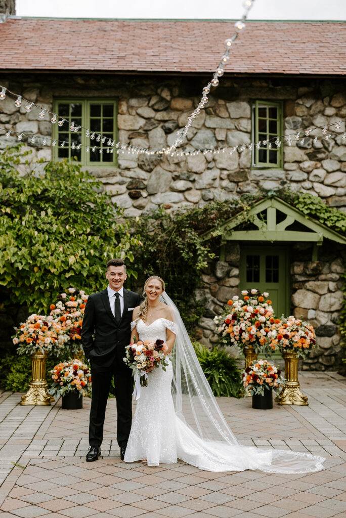 Bride and groom portrait at The Willowdale Estate in front of floral arrangement