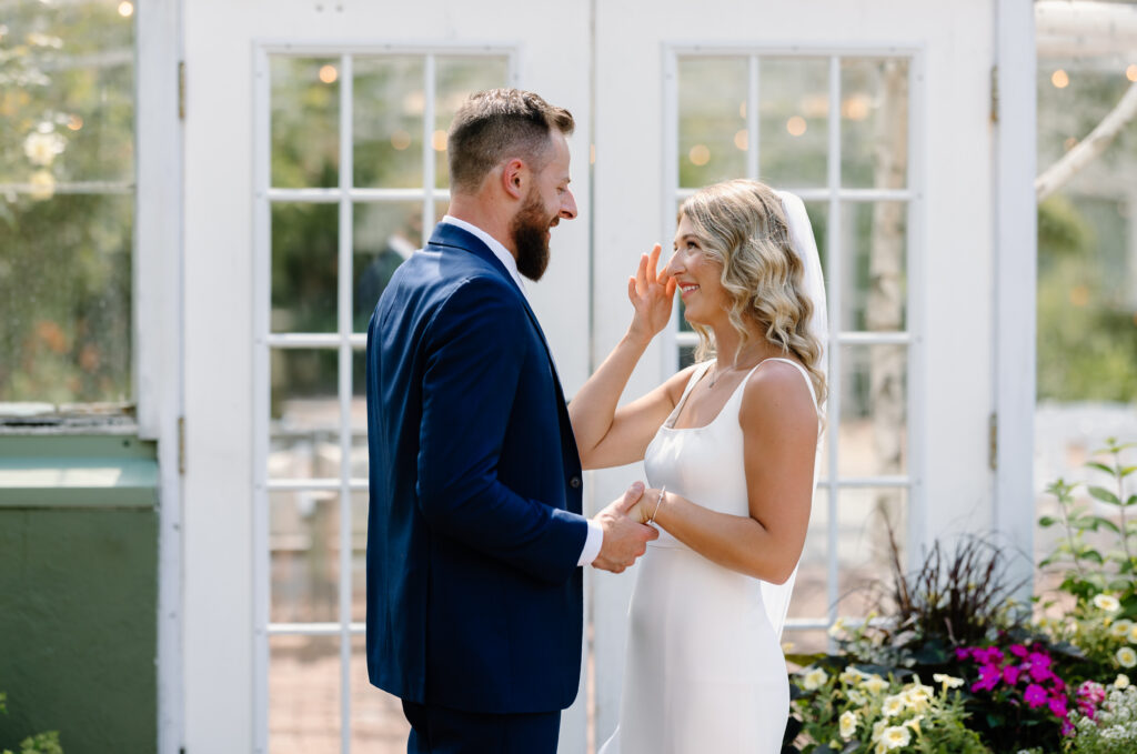 Bride wipes tear during first look with groom at Barn on The Pemi in Plymouth, New Hampshire