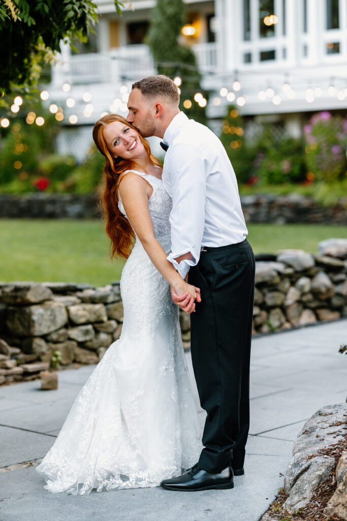 Groom kisses bride on cheek at The Bedford Village Inn Wedding venue in Bedford, New Hampshire