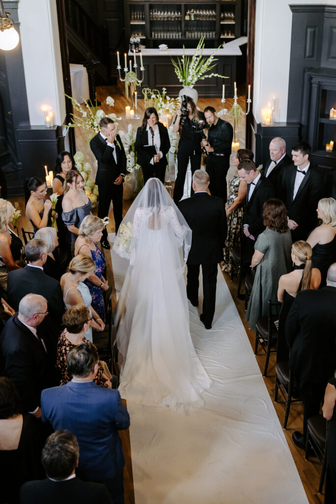 Bride walks down the aisle with her father to her groom at The Tower in Boston, Massachusetts