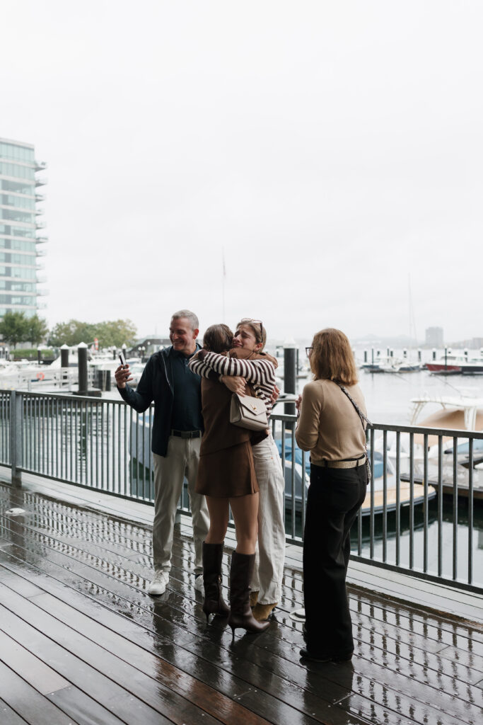 family hugging after surprise proposal