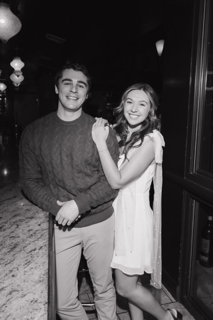 Bride and groom smile at camera during engagement session in Boston North End