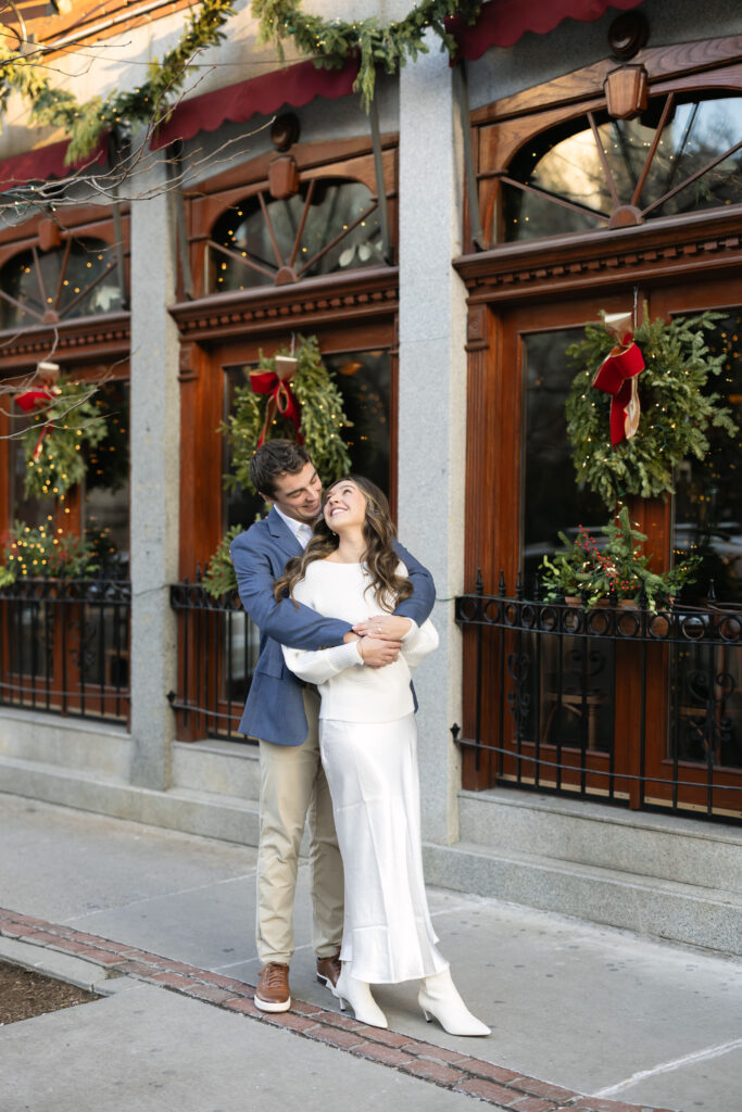 Groom hugs bride from behind during photo session in Boston