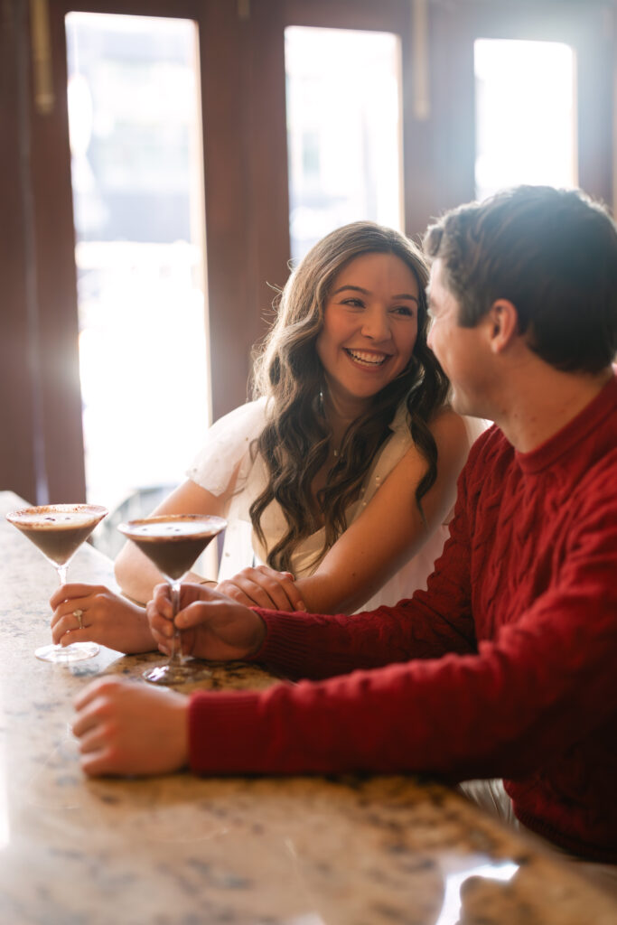 Bride smiles at groom at Boston bar engagement session