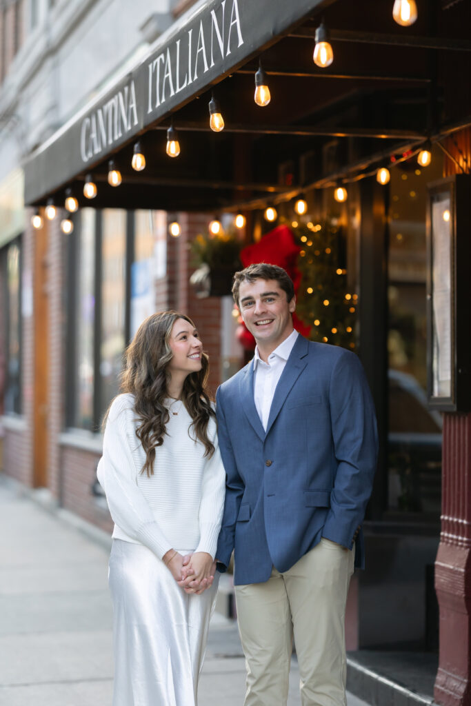 Bride looks at groom while he smiles at camera in Boston North End