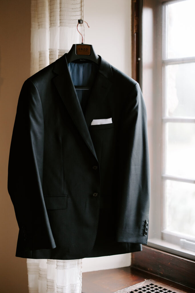 Groom's suit jacket hangs on a hook while groom gets ready for his fall wedding at The Willowdale Estate.