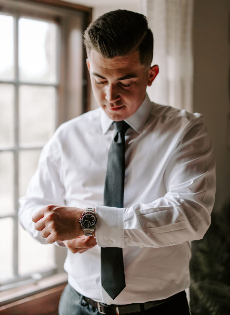 Groom puts on his watch as he gets ready for his wedding at The Willowdale Estate.