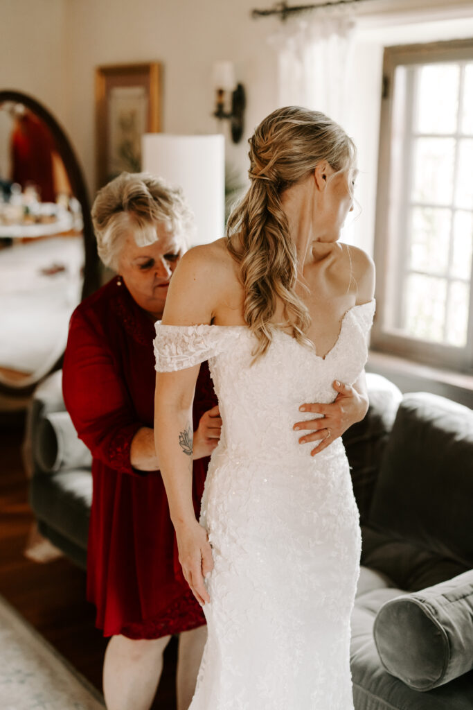 Bride's mother helps her into her wedding dress for her wedding at The Willowdale Estate.