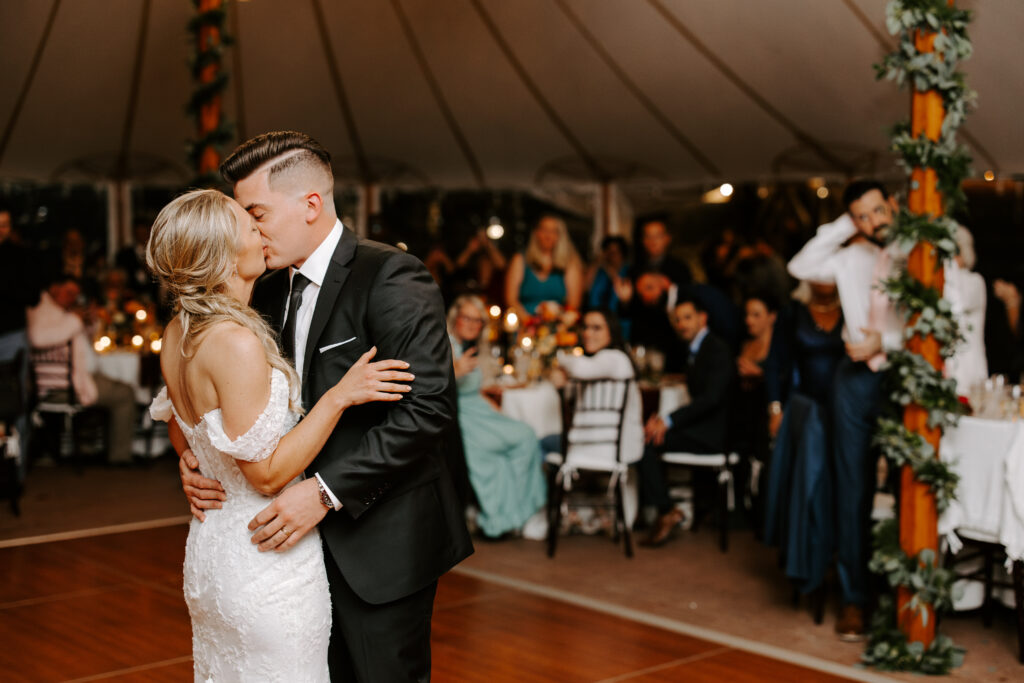 Bride and groom kiss while preforming first dance during their fall wedding at The Willowdale Estate in Topsfield, Massachusetts.