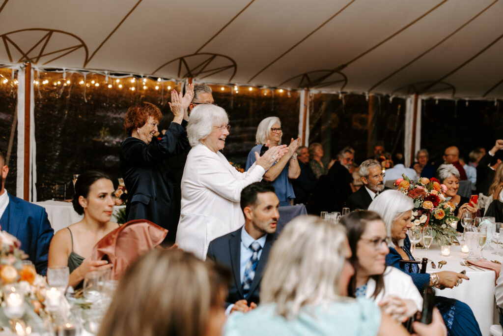 Guests cheer after bride and groom's first dance and welcome speech at their wedding reception at The Willowdale Estate.