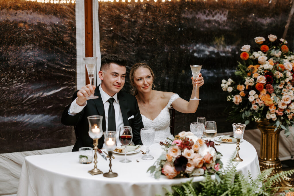Bride and groom raise their glasses for a toast at their fall wedding at The Willowdale Estate.