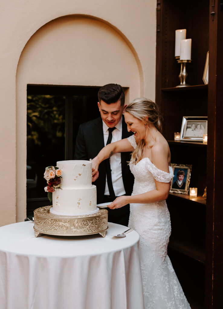 Bride and groom cut their wedding cake inside at The Willowdale Estate.