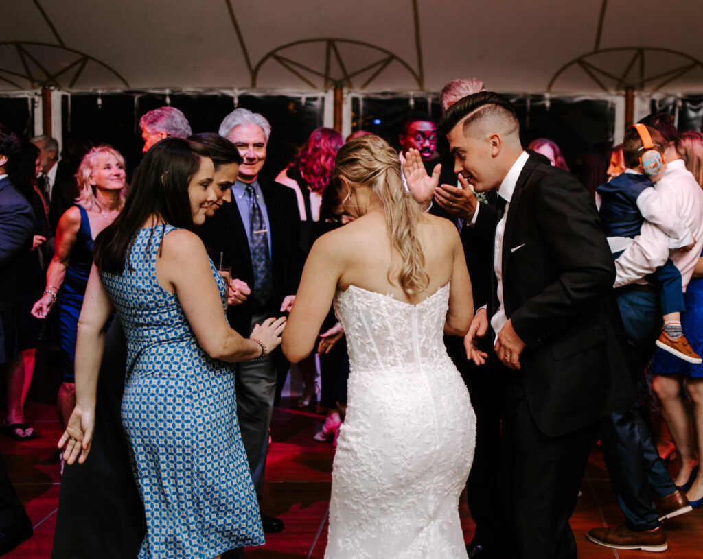 Bride and groom dance with guests during their wedding reception at The Willodale Estate.