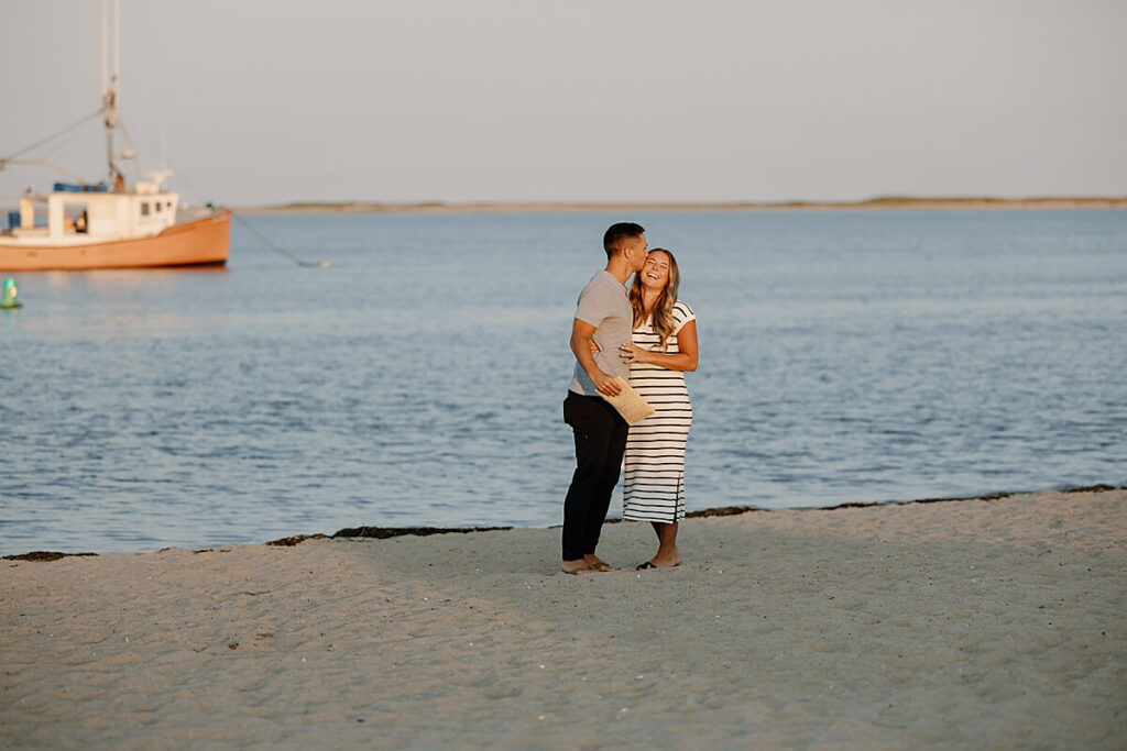 Groom kisses bride to be after his proposal on a Cape Cod beach