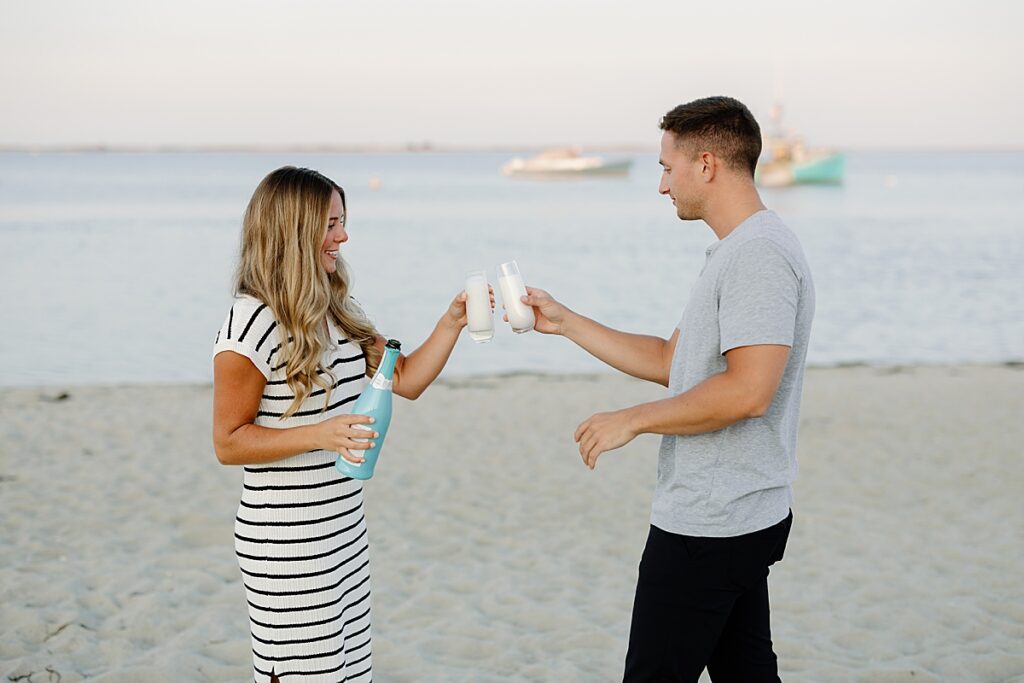 Bride and groom cheers champagne on the beach after proposal on the cape
