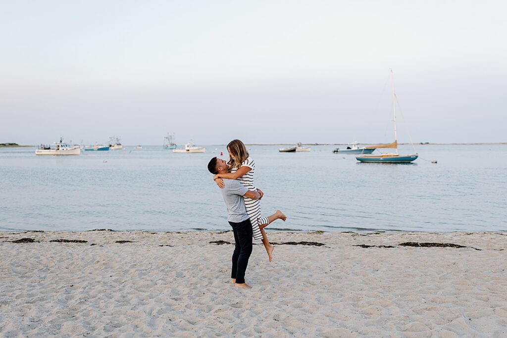 Groom to be holds bride on the beach after proposal on the Cape