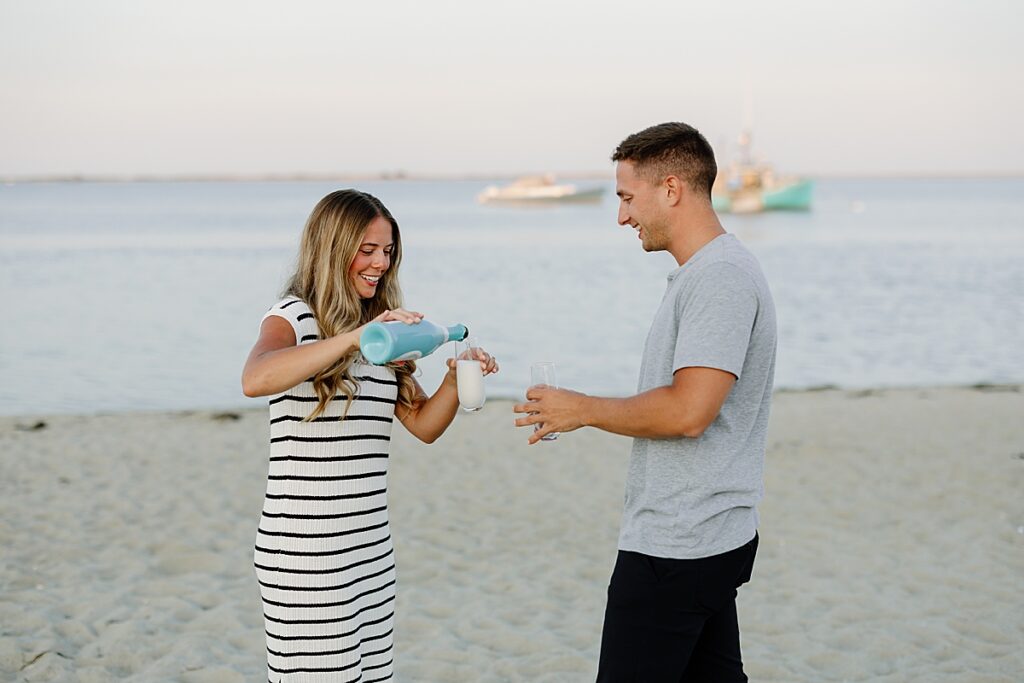 Bride to be pours glasses of champagne for herself and groom after proposal on the Cape
