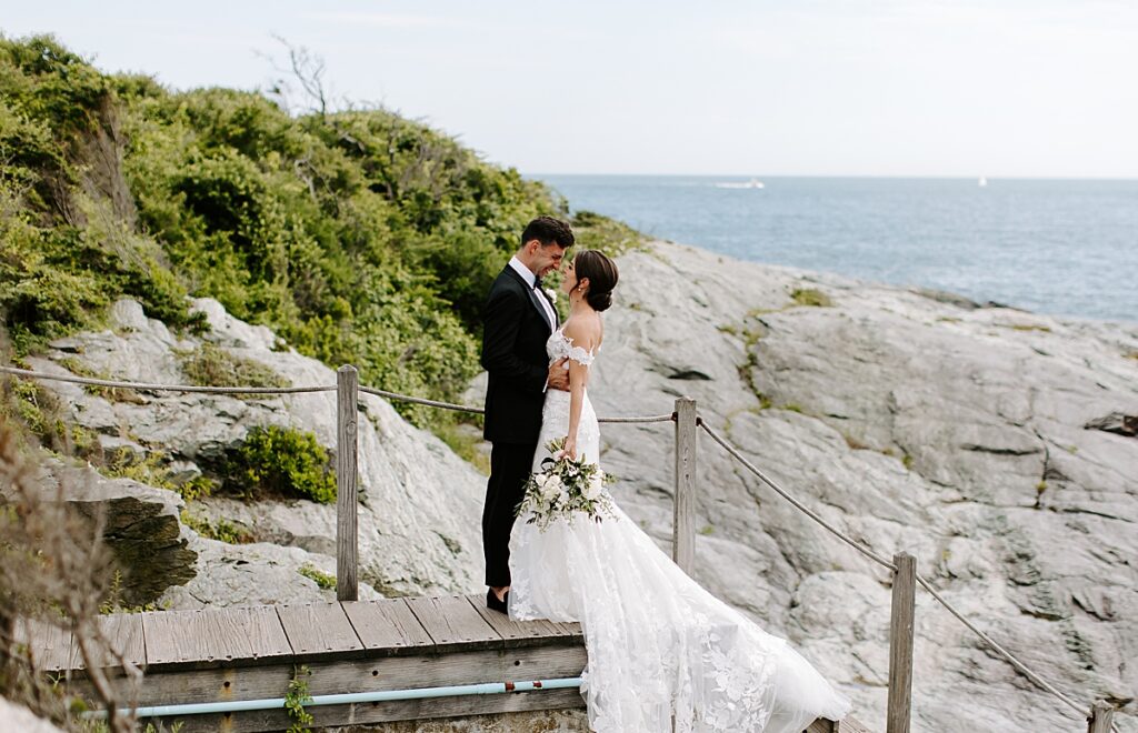 Bride and groom smile at each other on rocks at Castle Hill Inn in Newport, RI. The essential wedding planning steps for newly engaged couples
