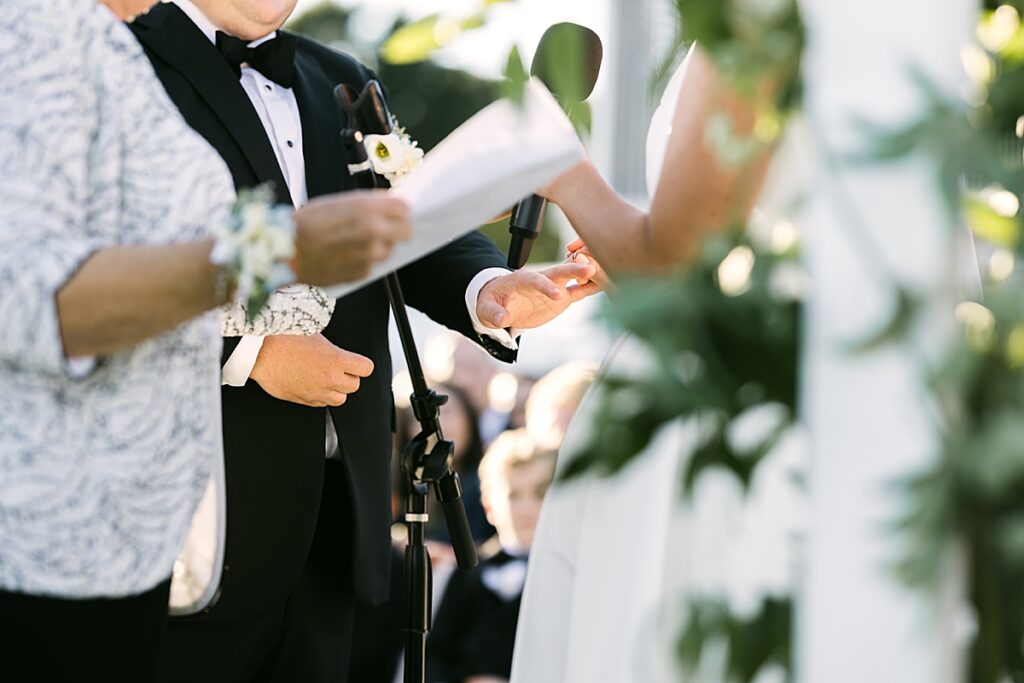 Bride puts grooms ring on during ceremony at Wiano Country Club in MA. Learn the essential wedding planning steps for newly engaged couples.