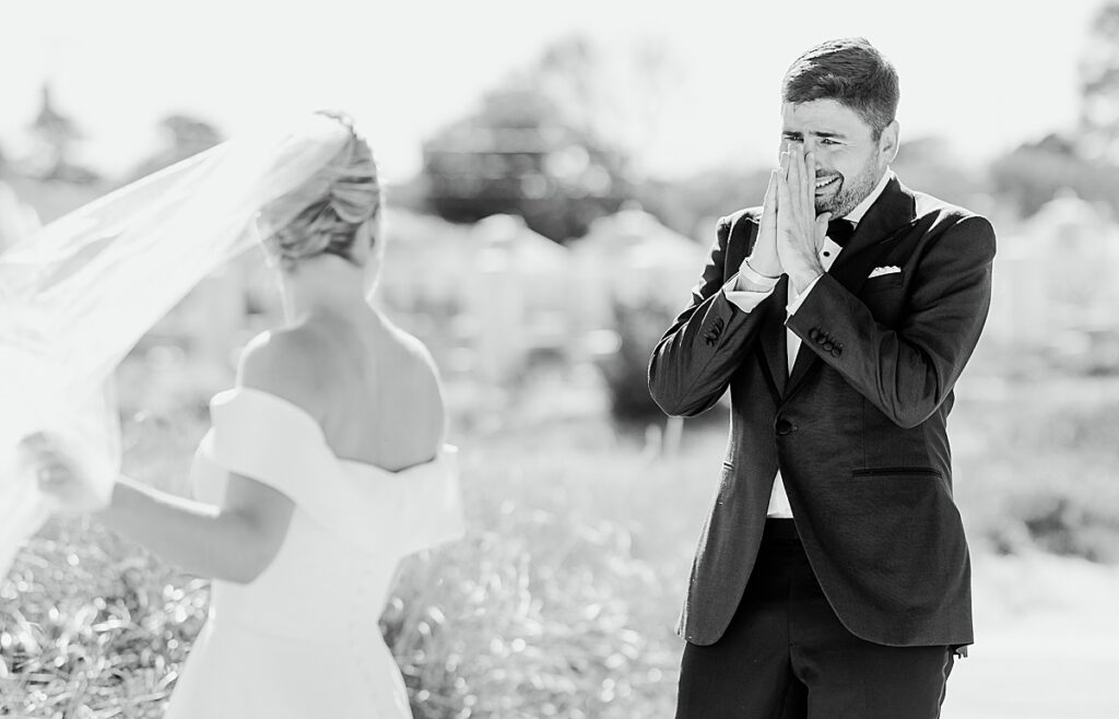 Groom cries while looking at bride during their first look on the beach in cape cod