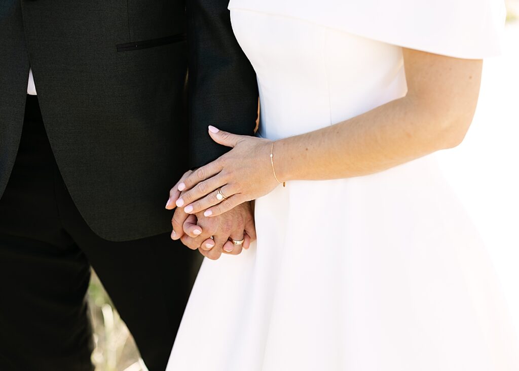 Bride and groom hold hands at wedding in Newport