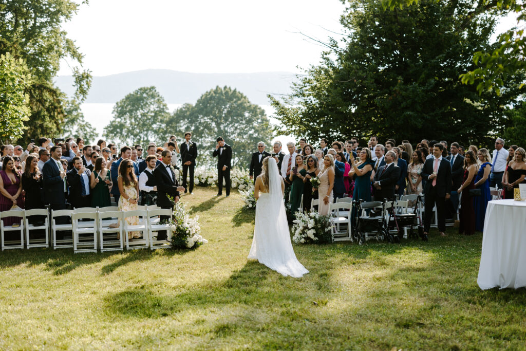 Bride walks down the aisle to groom during wedding ceremony in New York.