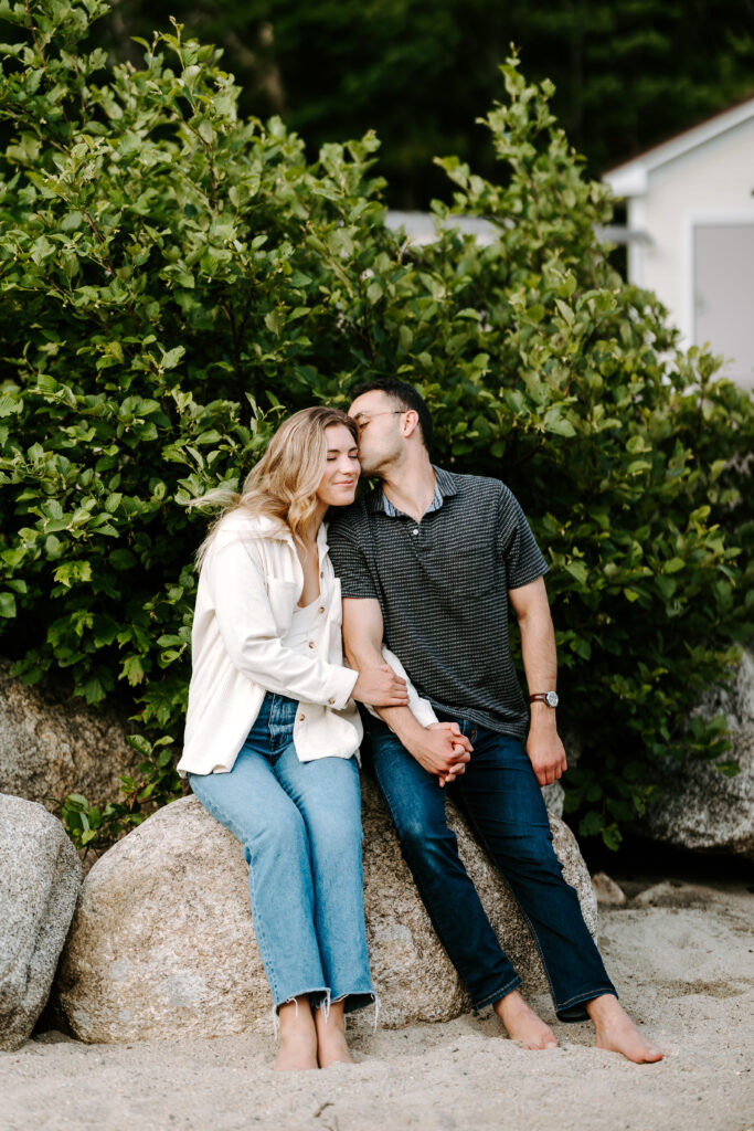 Soon to be groom kisses bride on the beach in New Hampshire
