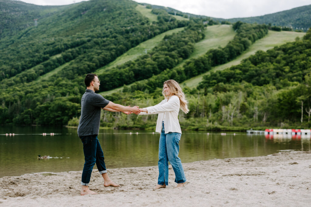 Bride and groom hold hands and smile at each other in New Hampshire white mountains engagement photos.