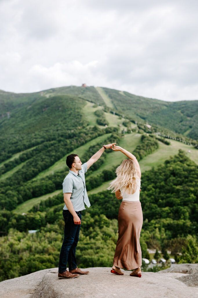 Groom spins bride in front of Cannon Mountain in NH