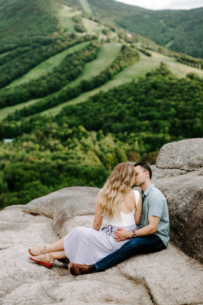 Bride and groom kiss on top of mountain in New Hampshire during engagement session
