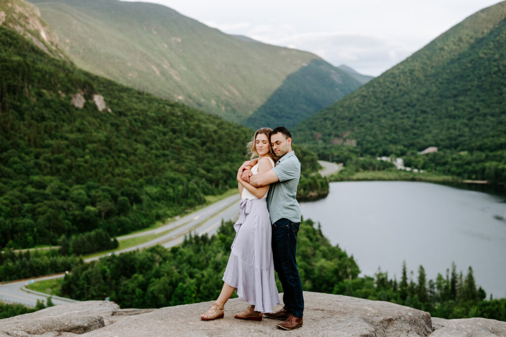 Bride and groom hug together and hold each other in NH white mountains engagement photos.