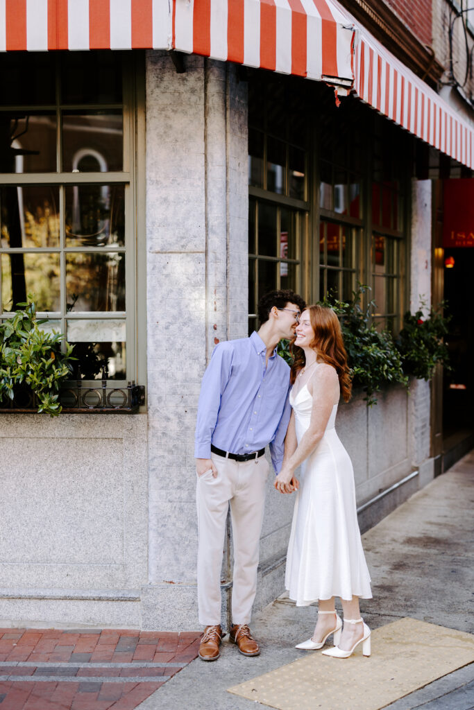 Groom whispers in brides ear on the street corner in boston