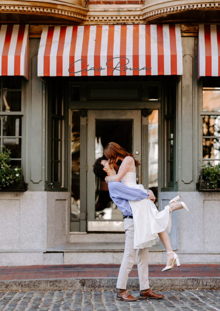 Groom lifts bride under the butt and kisses her during engagement photos