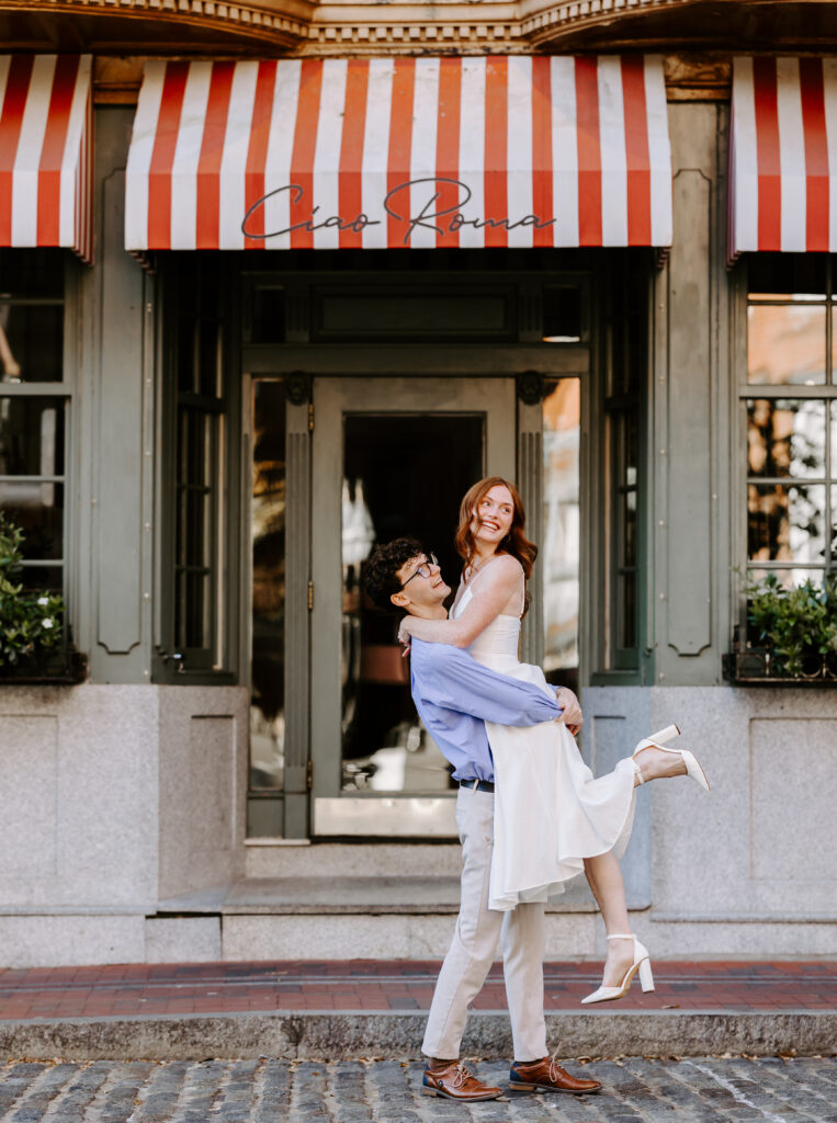 Groom lifts bride under the butt during engagement photos