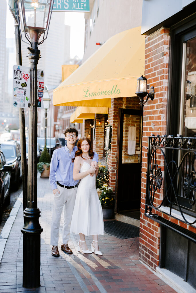 Couple smiles at camera on the street of boston for engagement shoot