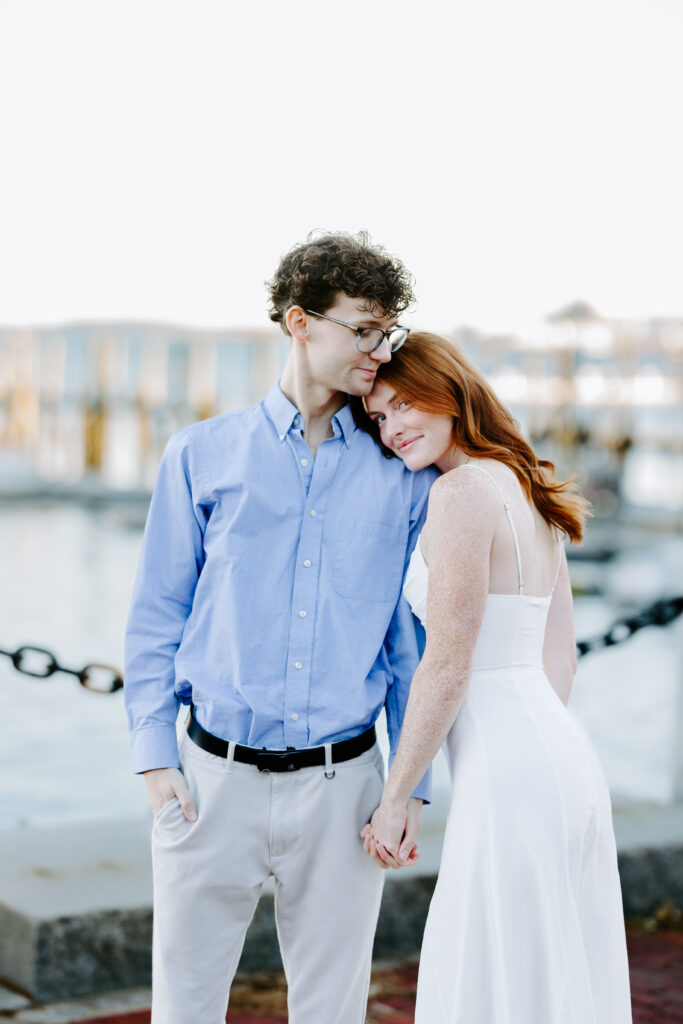 bride rests her head on grooms shoulder and smiles in seaport boston