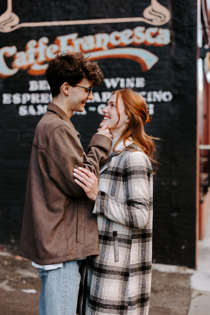 Downtown Boston engagement shoot couple smiles at each other