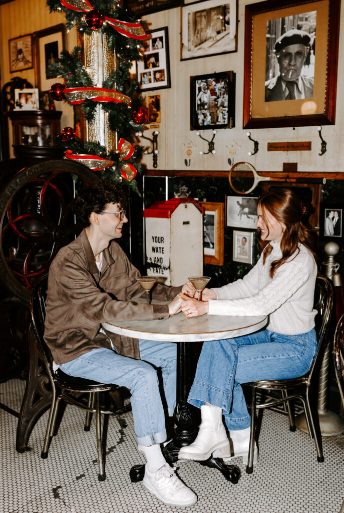 Bride and groom hold hands at a table in a cozy boston cafe